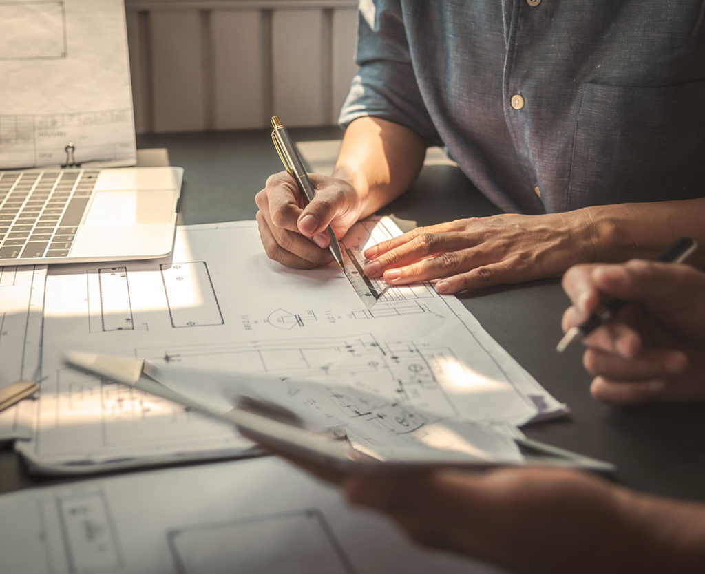 Architects sitting at desk with drawings